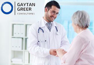 Confident doctor looking at his senior patient while speaking to her